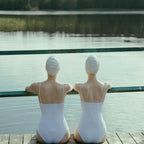 Zwei Schwimmer auf einem Steg an einem finnischen See