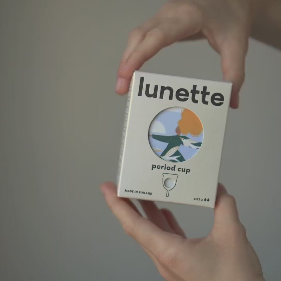 Auspacken der Lunette-Menstruationstasse: die Verpackung, der Leinenbeutel und die Tasse in der Hand
