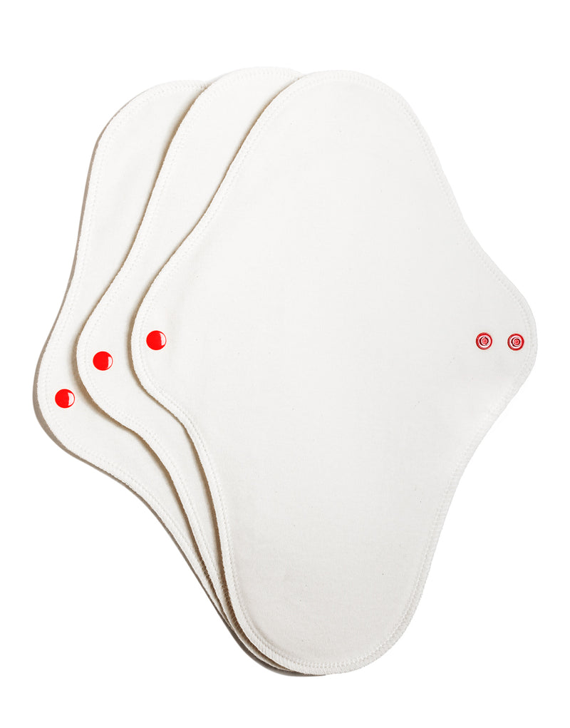 Three white reusable feminine pads with red buttons on the lower part, displayed on a white background.